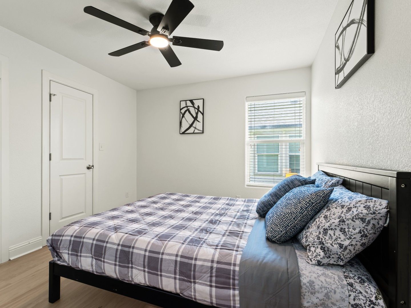 Furnished bedroom with queen bed and ceiling fan